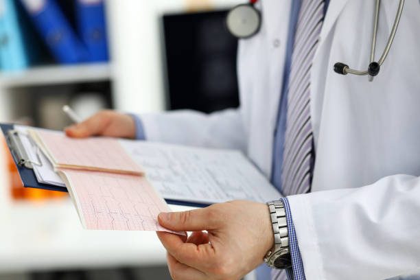 istock Male medicine doctor hands holding cardiogram chart 1322260652