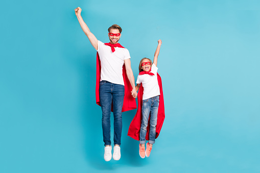 Full body portrait of brave little pupil positive guy flying raise arms fists up isolated on blue color background