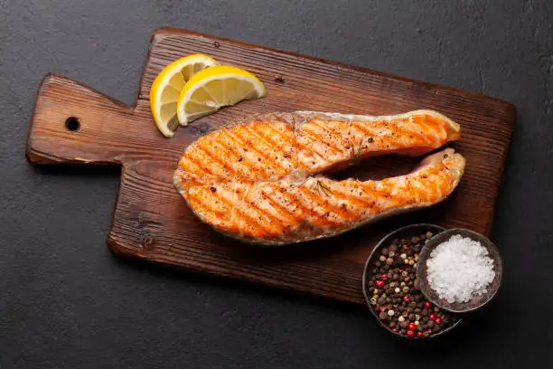 Photo of Grilled salmon steak. Fish steak with herbs and spices