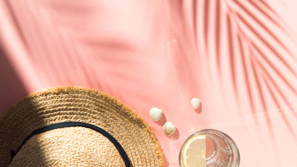 istock straw hat, water glass and shells on pink background flat lay 1322263887