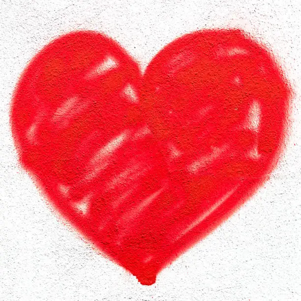 Red heart on grungy wall. Creative spray paint. Ideal for Love and Valentine's Day concepts.