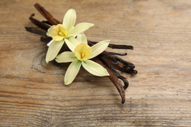 istock Aromatic vanilla sticks and flowers on wooden table, closeup 1322264733
