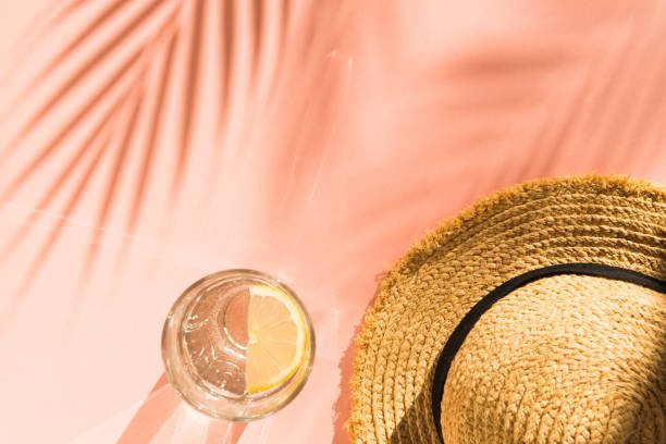 istock tropical vacation composition - straw hat and water glass on pink background flat lay 1322264791