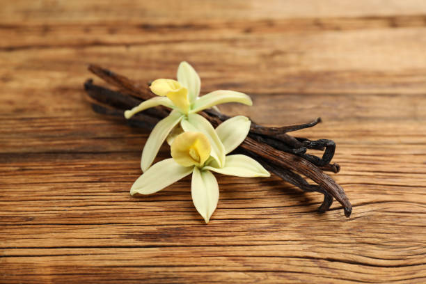 istock Aromatic vanilla sticks and flowers on wooden table, closeup 1322265666