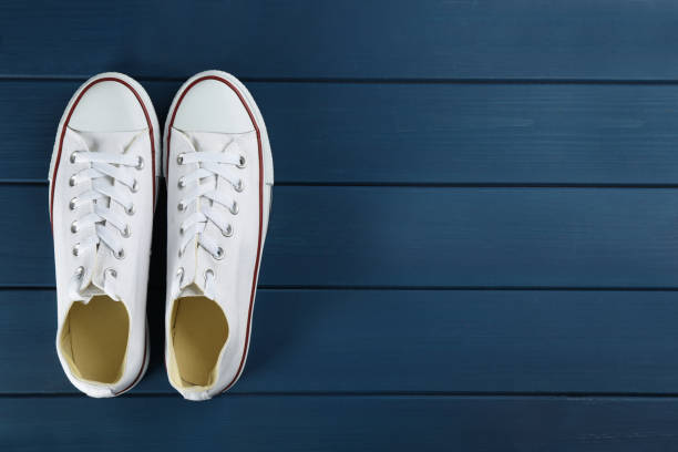 istock Pair of white sneakers on blue wooden table, flat lay. Space for text 1322266051