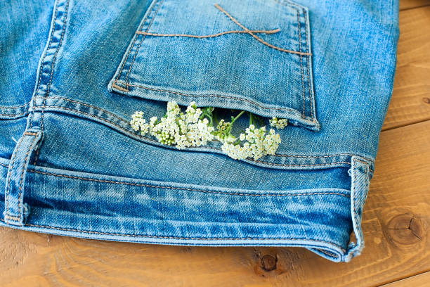 istock Pink Peony flowers on denim jeans blue cloth background, close up macro, copy space, text place. 1322268970