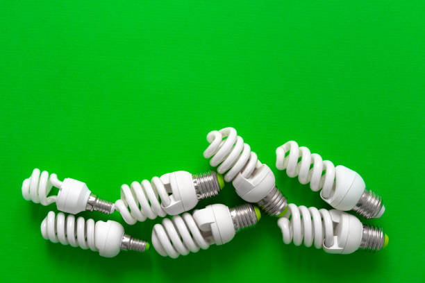 istock Light bulb on green paper background close up 1322269061