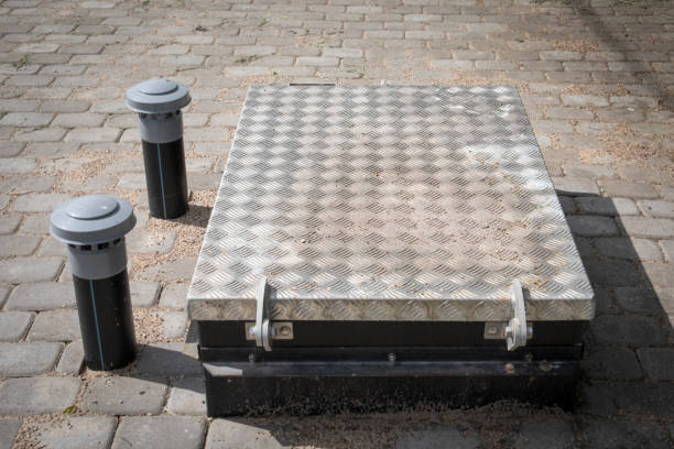istock Stainless steel manhole cover and plastic ventilation pipes. Sewerage system 1322269351