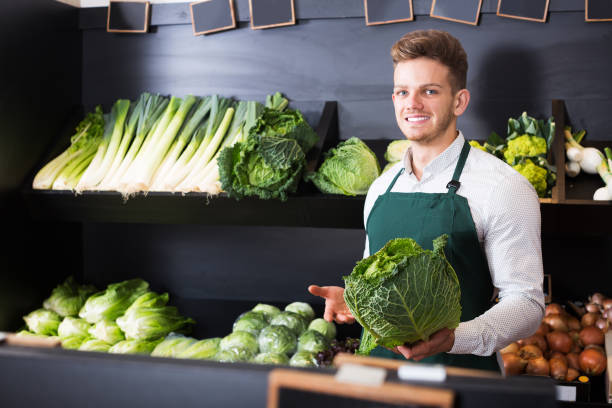 istock Seller showing cabbage in shop 1322270250