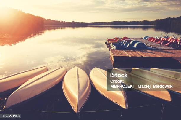 Kayaks And Paddle Boats By A Lake At Sunset Stock Photo - Download Image Now - Lake, Pedal Boat, Paddleboat