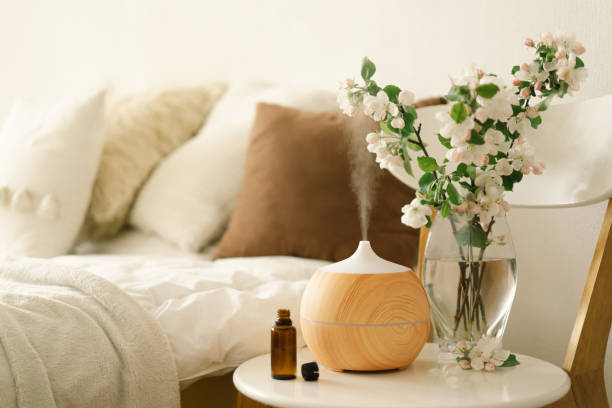 aromatherapie-konzept. aromaöl diffusor auf stuhl gegen im schlafzimmer. lufterfrischer. - aromatherapie stock-fotos und bilder