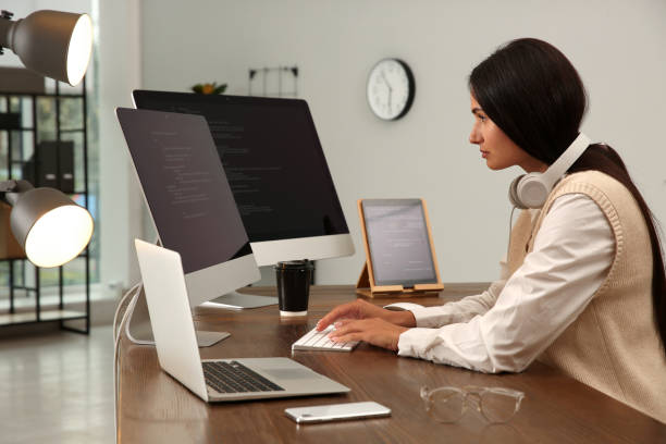 istock Programmer with headphones working at desk in office 1322277002