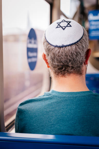 istock Jewish man wearing skull cap on passenger train 1322278124