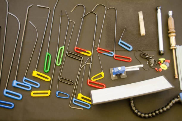 Paintless Dent Repair Kit Tools Set On The Work Table. Tools For Repair Dents On Car Body. Glue tabs With Slide Hammer, Lifter and Puller. Top View herramientas del kit de reparación de abolladuras sin pintura establecidas en la mesa de trabajo. herramientas para reparar abolladuras en el cuerpo del coche. pestañas de pegamento con martillo deslizante, elevador y tirador. vista superior.