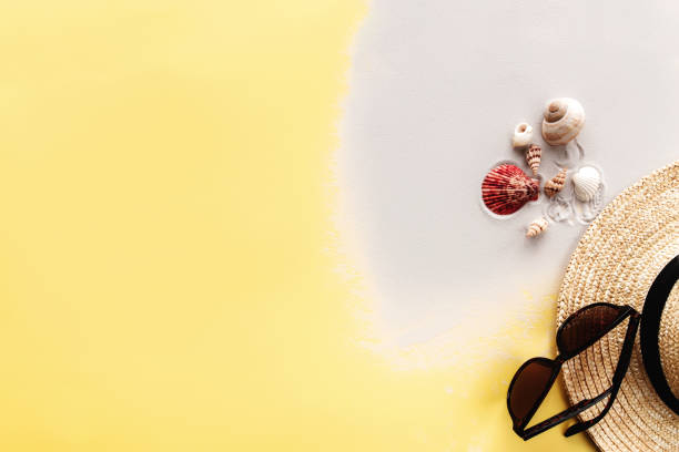 istock Summer background yellow flat lay with sand, shells, straw hat and sunglasses 1322280243