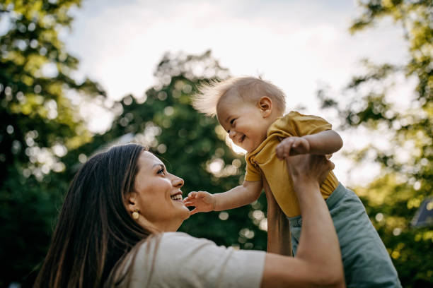 мать играет со своим ребенком - baby kissing mother lifestyles стоковые фото и изображения