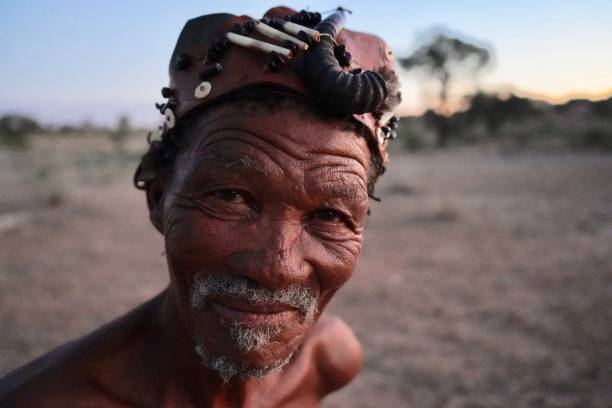 Descendant of the Kalahari Bushmen, at his home near the Transfrontier park. 3 March 2020 - Askham, South Africa : Portrait of a descendant of the Kalahari Bushmen, at his home near the Kgalagadi Transfrontier park, wearing traditional garments. bushmen stock pictures, royalty-free photos & images