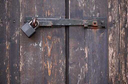 Open padlock with key and an old rusty link chain on a grunge orange background