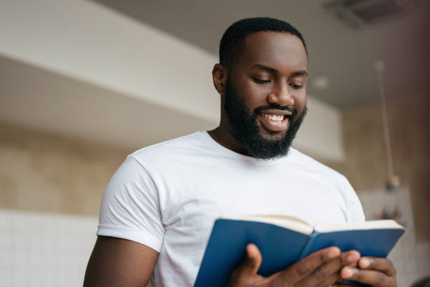 istock Handsome African American man reading book, exam preparation. University student studying, learning language, education concept 1322286159