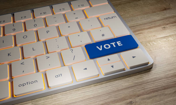 istock Close-up of a computer keyboard on a table. One computer-key is blue with the word Vote. 1322289382