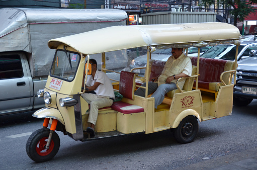 Bangkok, Thailand- Mar 24, 2015: Tuk-tuk moto taxi on the street in the Chinatown area in Bangkok. Famous bangkok moto-taxi called tuk-tuk is a landmark of the city and popular transport.