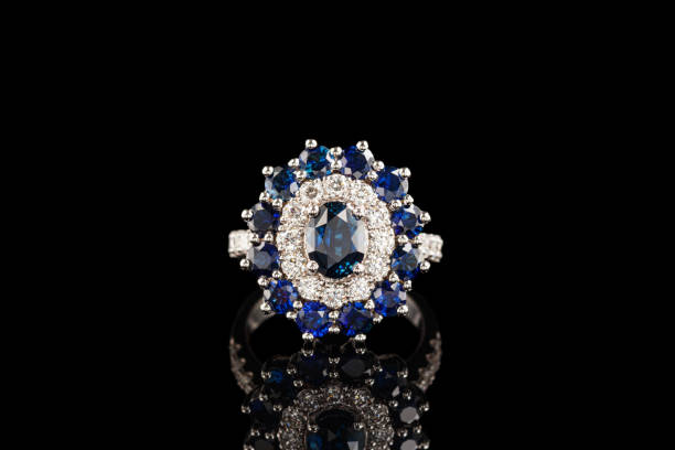 istock Beautiful ring with sapphires and diamonds in gold on a black background 1322289855