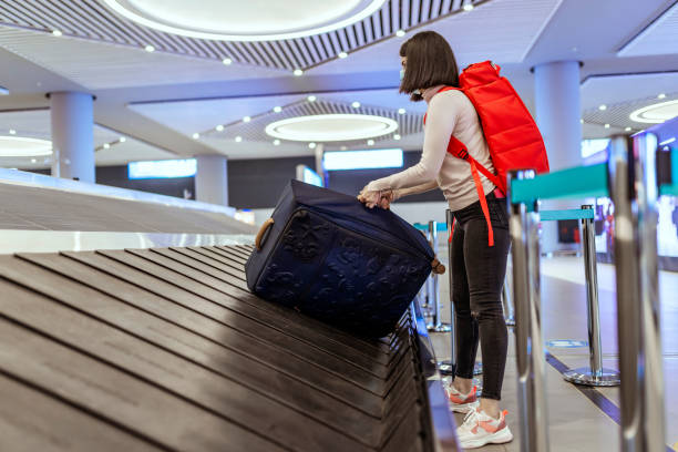 istock Passenger collecting baggage from conveyor belt at airport 1322290726