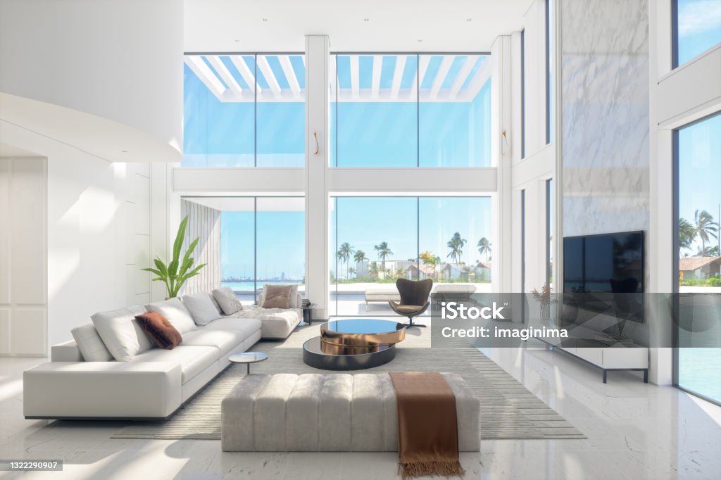 Luxury Modern Living Room Interior With Panoramic Sea View Large and luxurious interior of a fully furnished modern living room with panoramic sea and beach view. Luxury Stock Photo