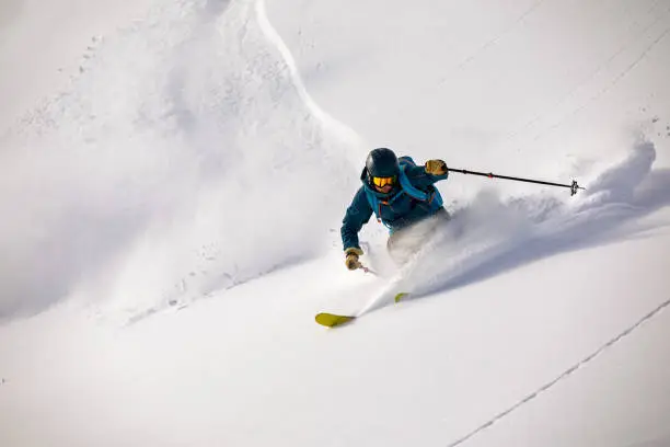 Photo of Back country skier riding down in deep powder snow