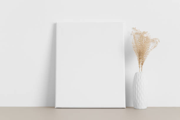 istock White canvas mockup with a dried flower on the beige table. 1322291289