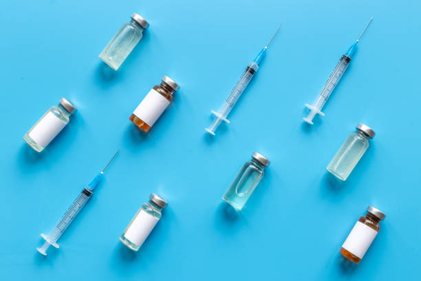 istock Vaccination with Covid vaccine in bottles with syringe 1322292167