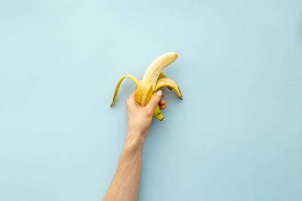 istock Hand holding peeled banana. Top view 1322292740
