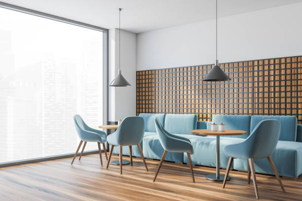 istock Modern cafe interior with wooden tables and blue chairs, panoramic windows 1322295222