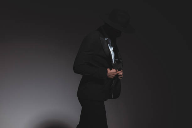 istock mysterious fashion model adjusting his jacket and looking down 1322295258