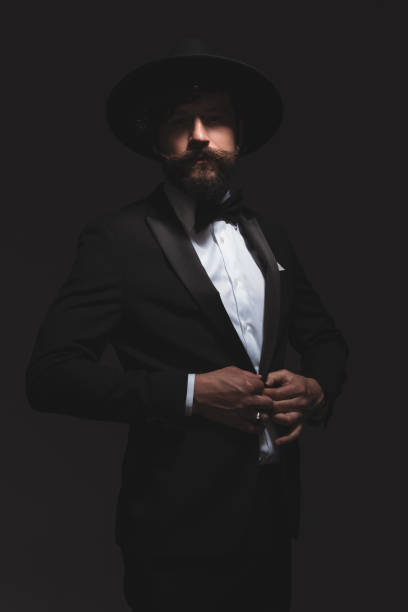 istock mysterious businessman adjusting his tuxedo while wearing a hat 1322295545