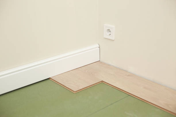 istock Installing wooden laminate or parquet floor in room over green base. assembling panels quickly and easily - affordable flooring. laying laminate flooring at home 1322299430