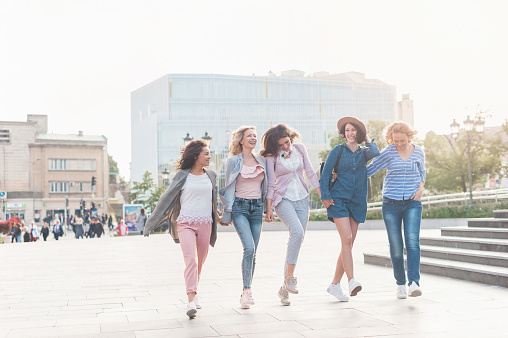 Diverse group of beautiful female friends happily walking together