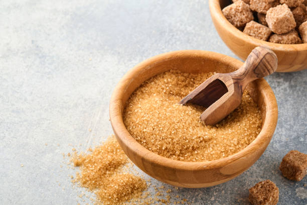 istock Cane sugar cube in bamboo bowl on gray table concrete background. Top view. 1322305718