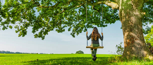 istock Woman on a swing by an oak tree 1322309680