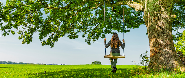 Woman on a swing by an oak tree