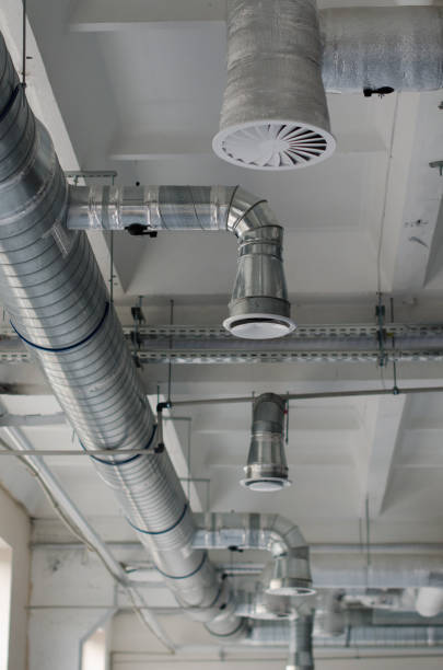 istock Air duct, air conditioner pipe is on white ceiling wall. Ventilation system are on the ceiling of large building. Air condition and hvac system installation under bareskin ceiling before interior finishing. Air flow and ventilation system. 1322309898