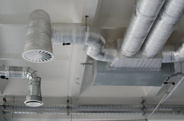 istock Ventilation pipes are in silver insulation material hanging from the ceiling inside new building. The system of industrial ventilating pipes. Air flow and ventilation system. 1322309930