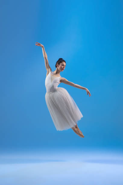 istock Young and graceful ballet dancer isolated on blue studio background. Art, motion, action, flexibility, inspiration concept. 1322311065