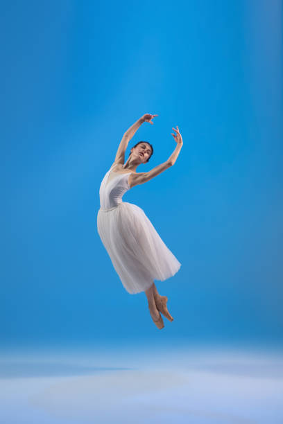 istock Young and graceful ballet dancer isolated on blue studio background. Art, motion, action, flexibility, inspiration concept. 1322311066