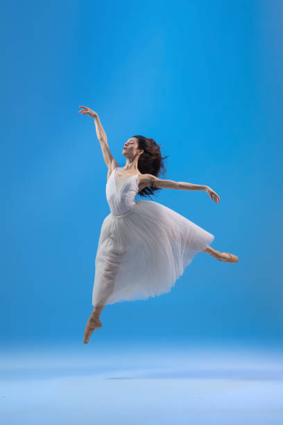 istock Young and graceful ballet dancer isolated on blue studio background. Art, motion, action, flexibility, inspiration concept. 1322311072