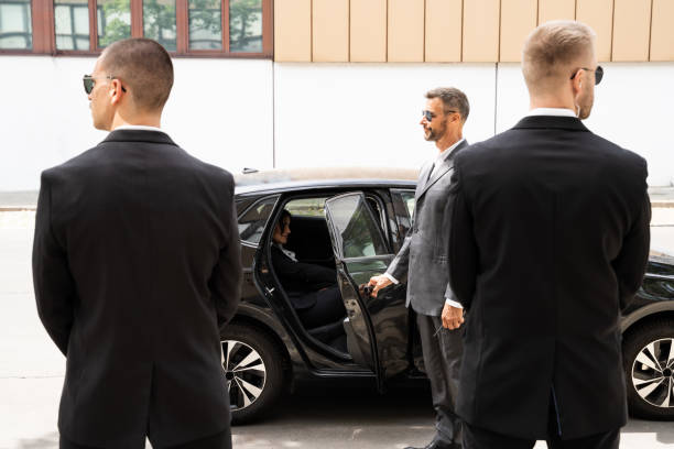 gardes du corps protégeant une femme d’affaires ouvrant la porte de la voiture - bodyguard photos et images de collection