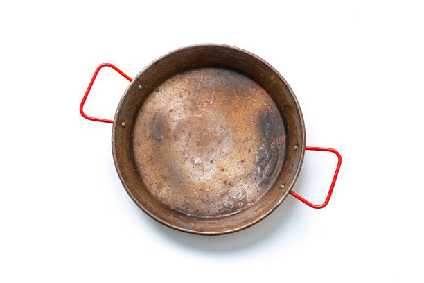 istock Old stained paella pan isolated on white background 1322313827