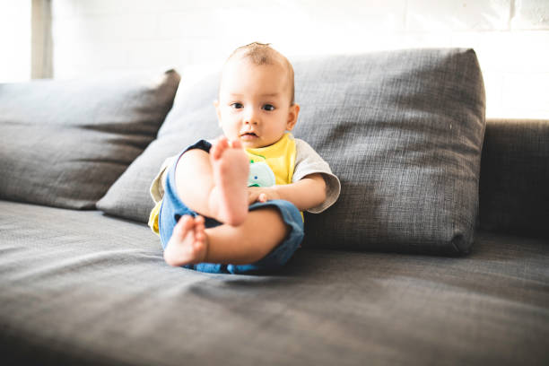 istock asian baby sitting alone on sofa bed 1322314740