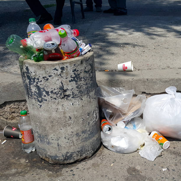 콘크리트 쓰레기는 가장자리에 유출 병의 전체 수 있습니다. 도시와 자연의 오염. 환경 충돌. - overflowing water glass bottle 뉴스 사진 이미지