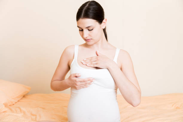 Close Up of pregnant women having painful feelings in breast. Woman checking her breast for cancer Close Up of pregnant women having painful feelings in breast. Woman checking her breast for cancer. Self Exam stock pictures, royalty-free photos & images